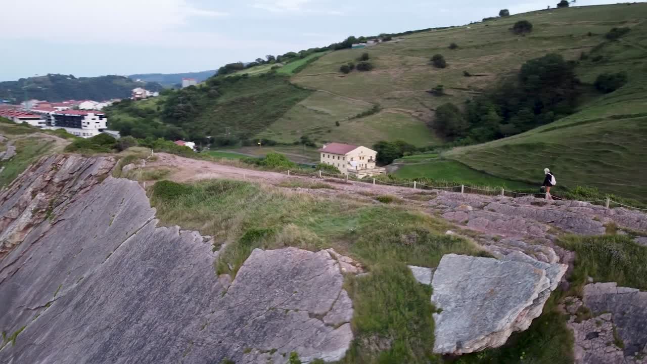 niña camina con una máscara en tiempos de pandemia a lo largo de los acantilados en el norte de españa, zumaia