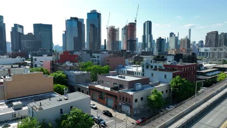 Drone-flight-over-Brooklyn-Greenpoint-District-and-Modern-Skyline-of-New-York-City-in-background---Construction-site-skyscraper-during-building-phase