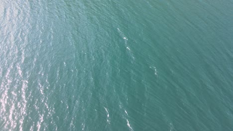 beautiful areal shot of como lake in italy, with clear water and small waves floating in 4k while sunset.