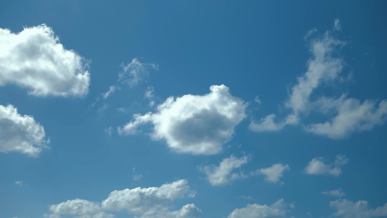 White clouds drifting across bright blue Caribbean sky above Atlantic Ocean during tropical cruise day