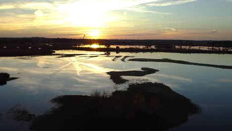 sun reflecting on watery marshland landscape, aerial drone view