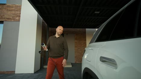 man charging an electric vehicle at home