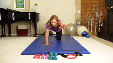 Front-view-of-a-woman-at-home-exercising-and-raising-her-hand-forward,-still-shot