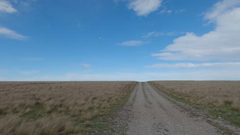 off-road cycling on 4wd track following contours in vast landscape - kaitorete spit