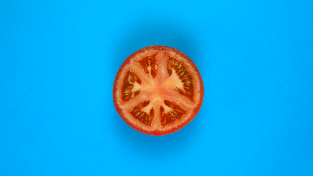 위쪽: 토마토 의 절반 이 파란색 표면 에 회전 - 빠른 움직임