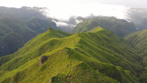 aerial view, pristine nature of madeira island portugal, green hills and clouds above natural park, drone shot