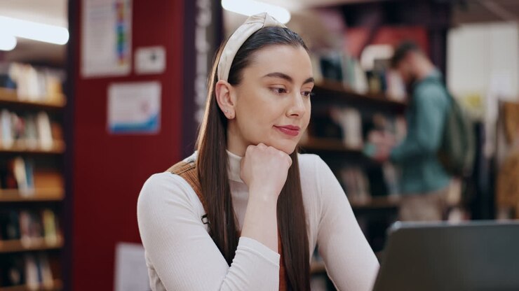 La donna che studia in biblioteca