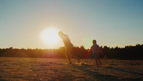 Padre-Sano-Jugando-Con-Su-Hijo-Al-Atardecer:-Representa-El-Avión-Y-Luego-El-Hijo-En-Un-Círculo