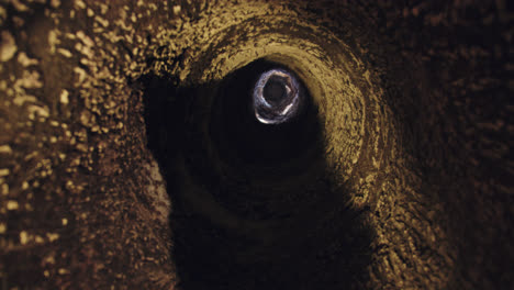 Amazing-slow-motion-shot-of-the-hole-in-a-cavern-that-serves-as-a-subway-wine-cellar-in-Burgos,-Spain