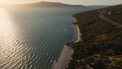 Shark-bay-during-a-windy-day-with-kitesurfers,-close-to-sunset,-aerial-shot