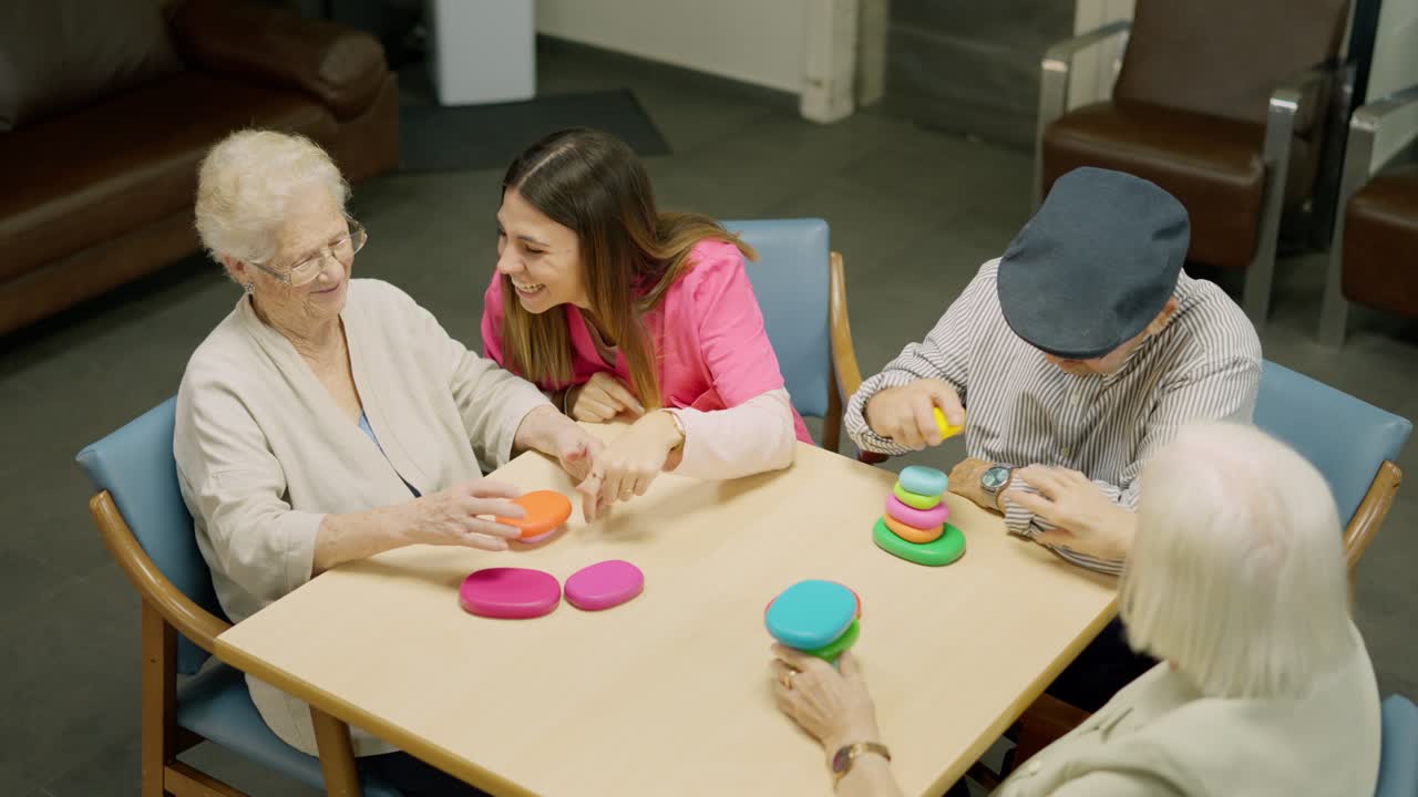 Seniors and caregiver playing stacking ring game