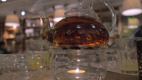 glass teapot being heated with candle