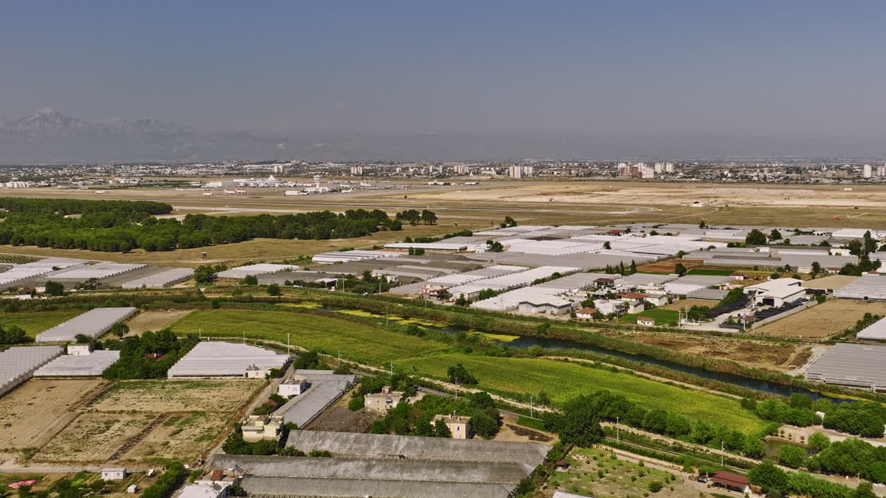 antalya turquía aérea v56 tierras de cultivo elevadas en yenigöl llenas de invernadero de plástico con aislamiento de aire de horticultura con arroyo duden cruzando con vista al aeropuerto - filmado con cine mavic 3 - julio de 2022
