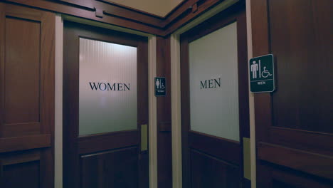 panning shot of two indoors restroom entrances