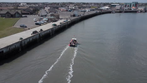 Vista-Aérea-De-Un-Pequeño-Barco-De-Pesca-Entrando-En-El-Puerto-De-Amble-En-Northumberland,-Reino-Unido