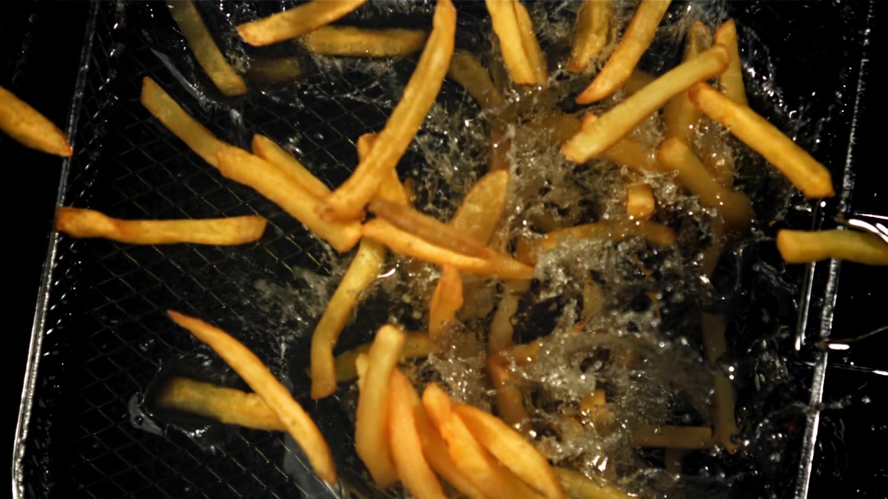 Close-Up of French Fries Dropping into Hot Frying Oil
