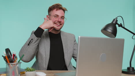 hombre de negocios mirando a la cámara haciendo gesto de teléfono, hey me llamas de vuelta, comunicando, reunión