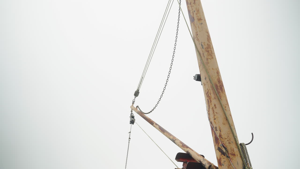 Tilting shot of fishing equipment boat lift on pier in Maine 4k 30p
