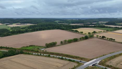 dramatic overcast on farm fields with brown and yellow harvested plantations. american countryside in pennsylvania, usa. aerial wide shot. peaceful nature of usa