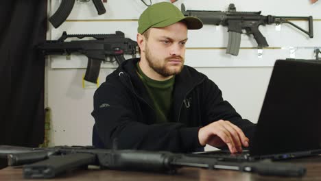 hombre detrás de un mostrador en una tienda de armas 3