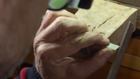 man working on a metal with a file