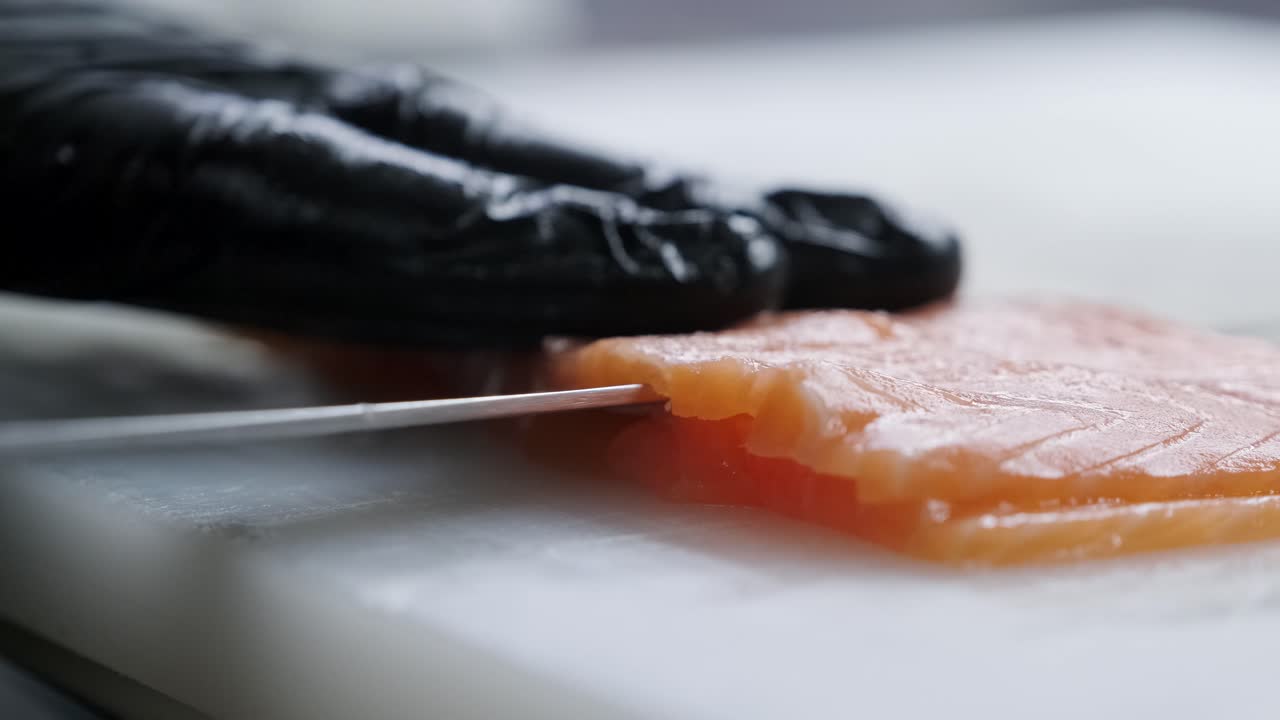 koch schneidet roten fisch mit einem messer