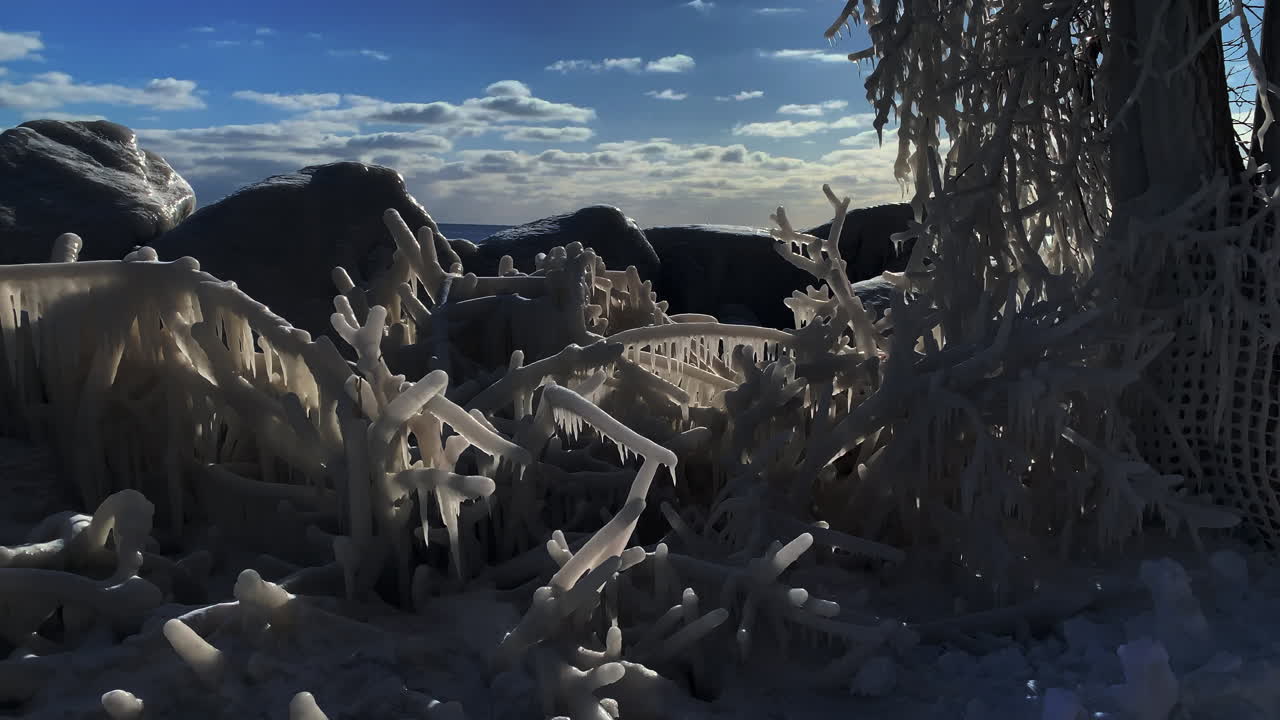 Late afternoon sun shining through natural ice formations created by extreme polar vortex weather, wide shot with jib down