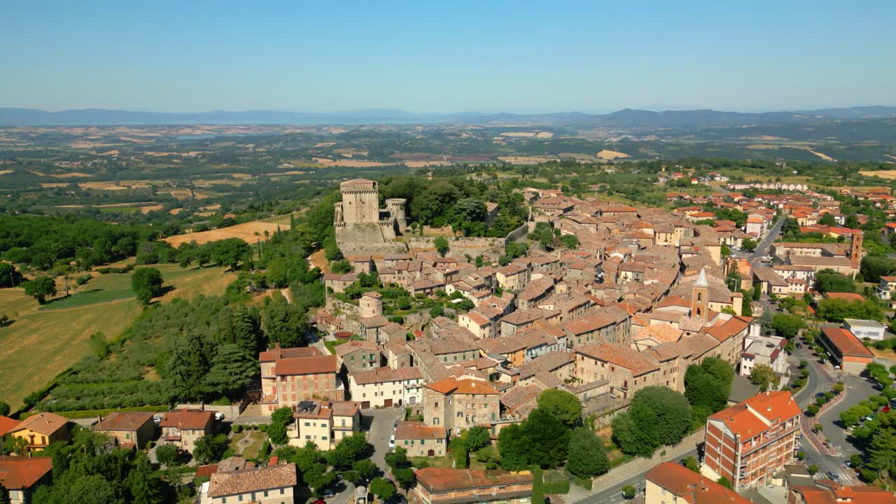 Castello di sarteano, a picturesque medieval village in tuscany, italy, showcases its historic architecture and surrounding landscape under a clear blue sky