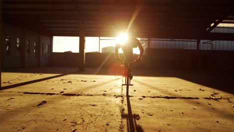 bmx rider in an empty warehouse