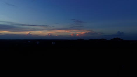 Imágenes-Aéreas-De-La-Hora-Azul-Durante-La-Puesta-De-Sol-Que-Revelan-Las-Luces-De-La-Ciudad-Y-Una-Carretera