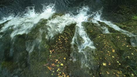 scenic view of waterfall on rocks with green moss in forest