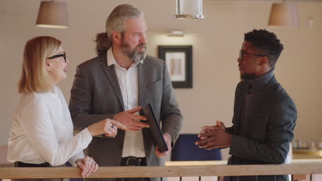 un hombre de negocios negro hablando con sus colegas caucásicos.