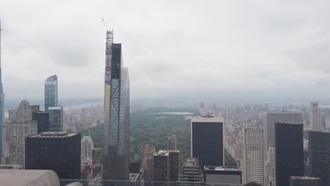 young man leaving top of the rock observation deck with amazing view of new york and central park under rainy clouds
