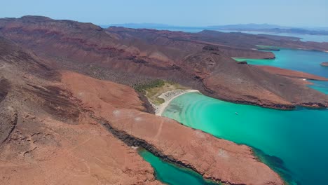 Strafe-Aerial-of-Powerboats-in-a-Private-Beach-Cove-with-Scenic-Mountains-and-Islands-Background