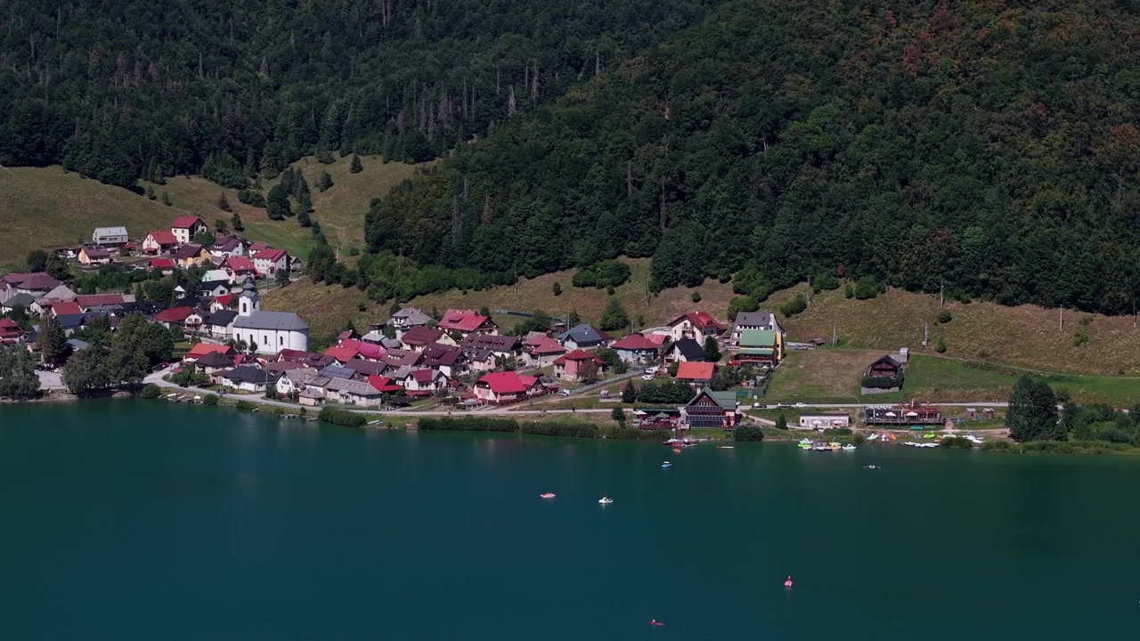Geleneksel evleri ve bir kilisesi olan, yemyeşil ormanlar ve sakin mavi sularla çevrili pitoresk bir göl kenarı köyü.