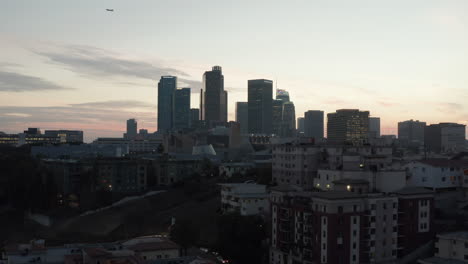 AERIAL:-Breathtaking-wide-shot-towards-Downtown-Los-Angeles,-California-Skyline-at-Sunset