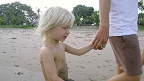 cute kid walking with parents on beach