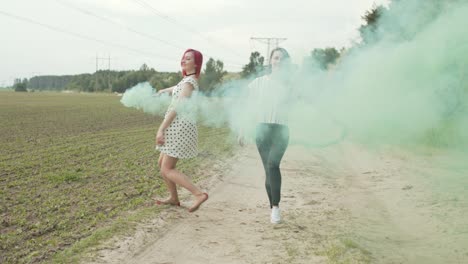 women with colored smoke bombs relaxing in nature