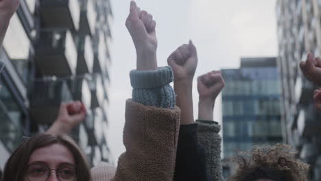 vista de cerca de activistas levantando puños durante una protesta contra el cambio climático en la calle