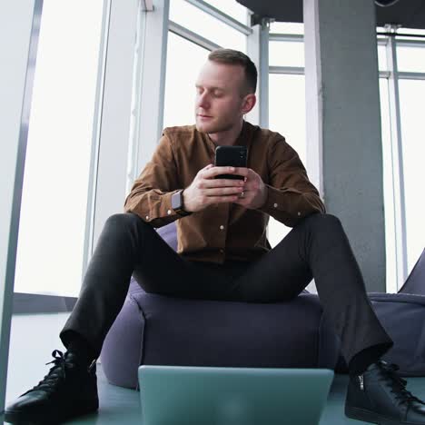 young man with laptop and mobile phone. man an is working remotely