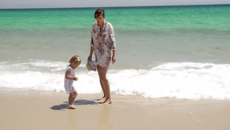 young mother with her daughter at the sea