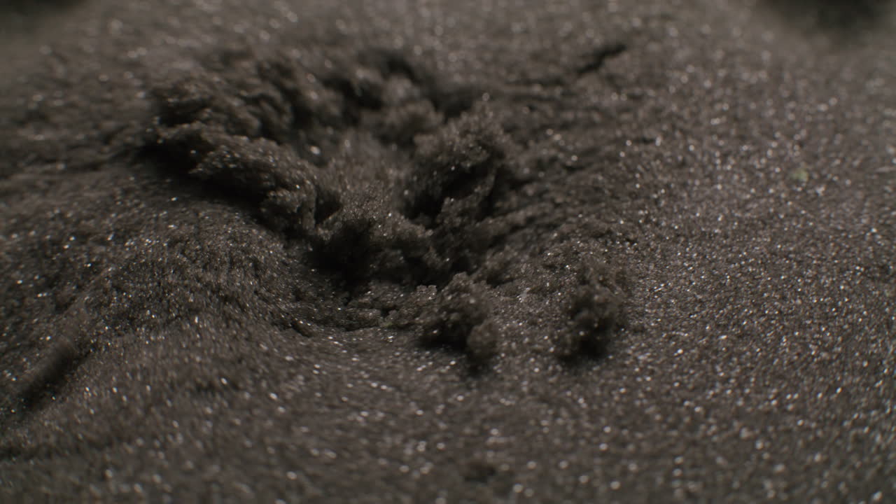 Close-up view of dark sand-like material