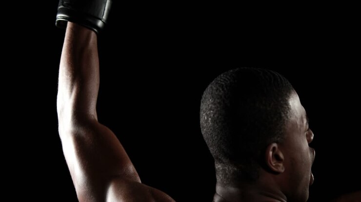 Rear view of boxer raising arms