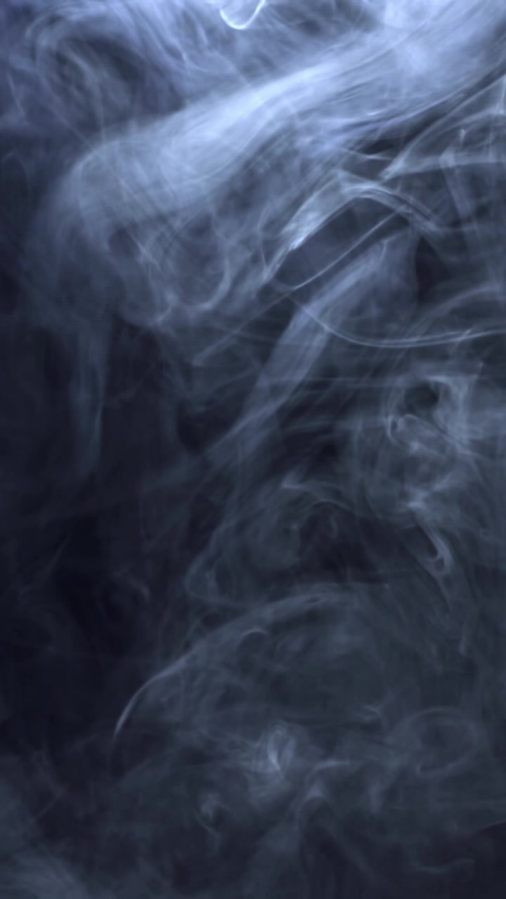 Etereo fumo bianco che volteggia su sfondo scuro
