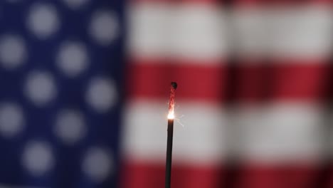 video of close up of sparkler with copy space over flag of usa