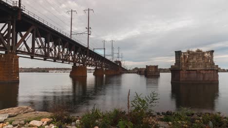 Timelapse-of-storm-clouds-passing-through,-trains-zooming-by-and-boats-cruising-in-the-water