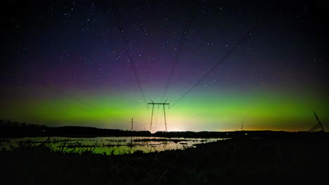 Timelapse-De-Auroras-Y-Nubes-Sobre-Cables-Eléctricos-Y-Campos-Húmedos-Y-Reflejados