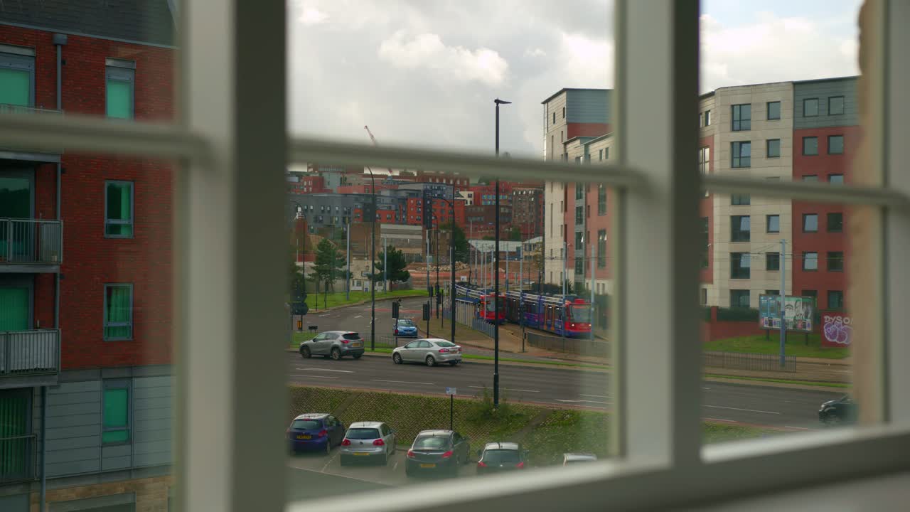City View from a Window: Tram and Traffic on a Cloudy Day