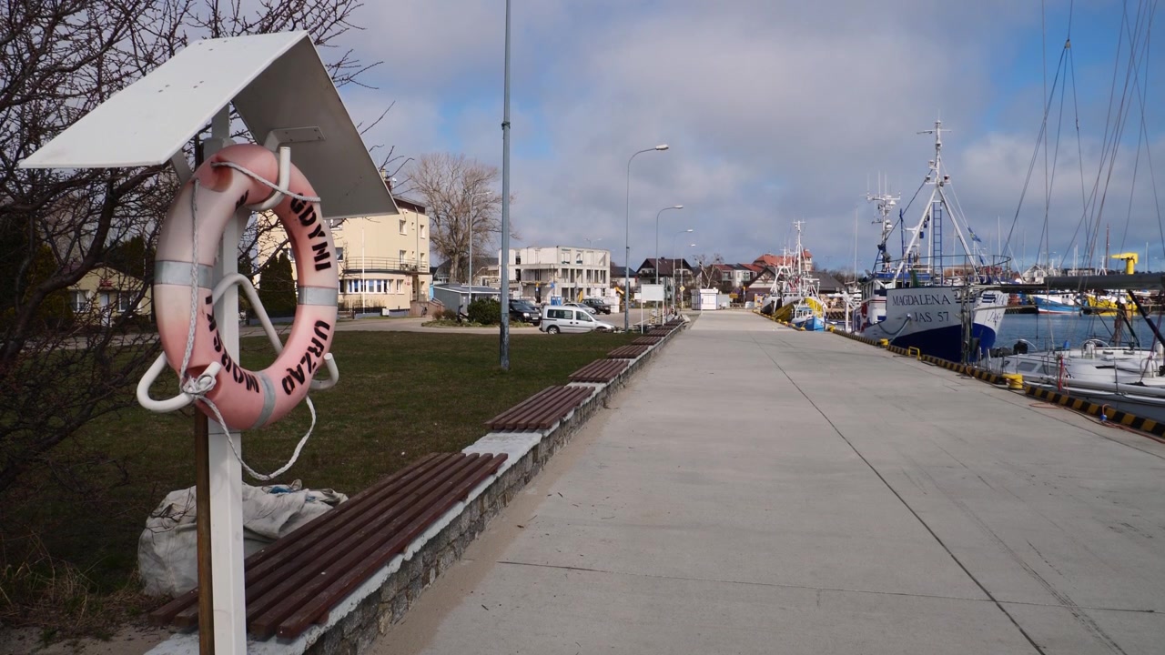 En klassisk misfarvet rød og hvid redningskrans hænger på molen i Jastarnias fredelige havn i Polen, Østersøen