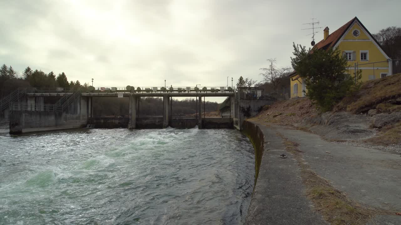 태양이 4k에서 빛나고 있는 동안 위어를 통해 흐르는 강의 흐르는 물의 시간 경과